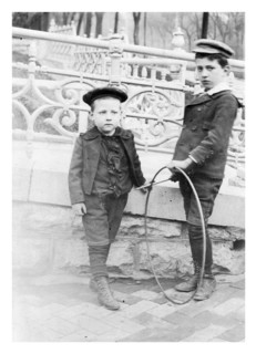Two boys playing with circular hoops c1900