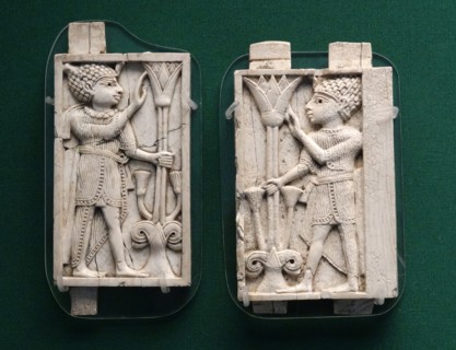 Relief panels depicting two youths dressed in Egyptian royal costumes grasping a tree formed by a lotus flower rising from a double volute