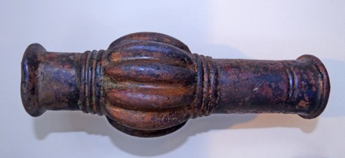 A tube decorated with grotesque features