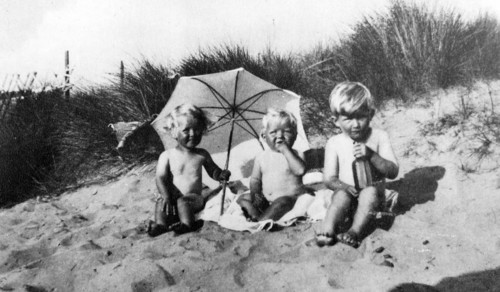 Vintage photograph of three children on a sandy shore 1930
