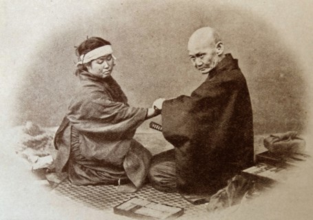 Portrait of a medical man attending to a patient in old Japan