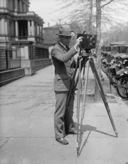 Man using a motion picture camera on a tripod