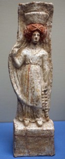 Terracotta figure of a woman wearing a chiton and Polos crown