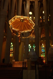 View of the suspended crucifix and glass altar within the Basílica i Temple Expiatori de la Sagrada Família