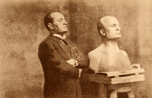 Benito Mussolini posing for his bust