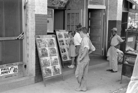 Children looking at posters in front of movie, Saturday, Steele, Missouri 1938
