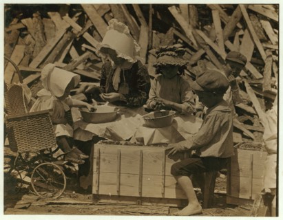 Mother and children hulling strawberries