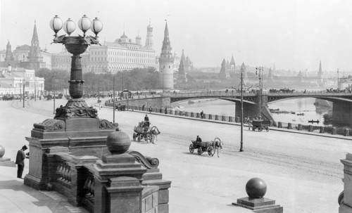 Photograph of horse-drawn wagons and motor trucks