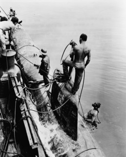 crewmen of the US Navy tug Ortolan fasten midget Japanese submarine to the side of their ship 1917