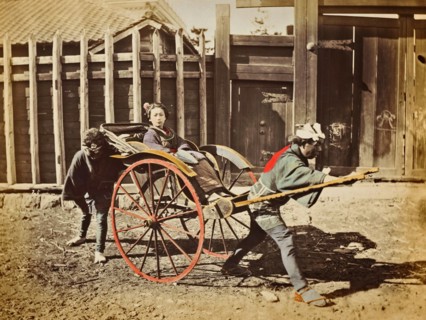 Colour photograph of Japanese women in a rickshaw, with two drivers