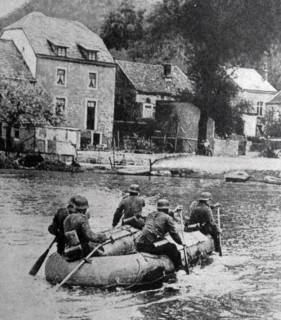 Photograph of Nazis paddling a rubber boat across a river in Belgium
