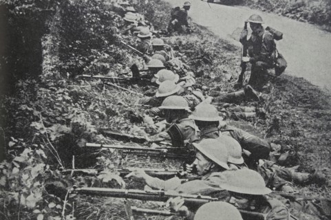 Photograph of Soldiers taking up position by the roadside