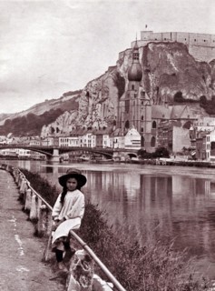 Girl sitting on a barrier by the Citadel of Dinant, Belgium.