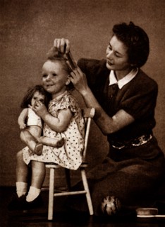 Photograph of a mother brushing hair young daughter's hair