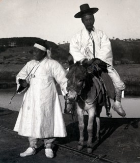 Korean official on a donkey led by a servant. Joseon Era. Circa 1900