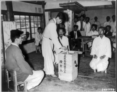 A Korean citizen drops a vote into ballot box during the first democratic election in Nae Chon, Korea