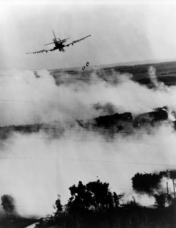 Two bombs tumble from a Vietnamese Air Force A-1E Skyraider over a burning Viet Cong hideout near Cantho, South Vietnam