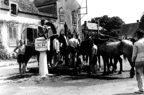 German soldiers washing in the fountain of a village near Courtenay, 1940