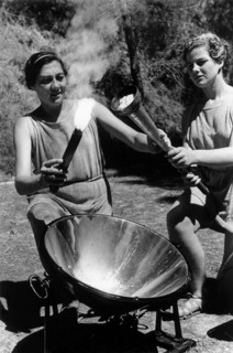 Olympiade, Griechinnen beim Entfachen der Flamme mittels Sonnenstrahlen in einem Hohlspiegel im heiligen Bezirk von Olympia