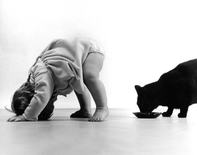 Baby watching cat through the legs