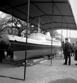 Visitors look at the model of a cruise ship exhibited around 1950