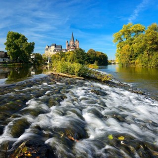 Limburg Cathedral St. Georg or Georgsdom and Limburg Castle over the river Lahn with weir in autumn