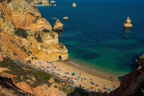 Swimmers on the beach between steep cliffs