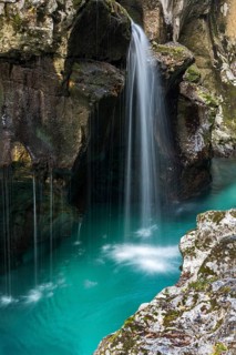Emerald green wild river Soca flows through rocky gorge