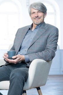 Man sits in his office chair with a coffee cup