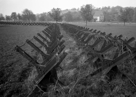 Tanks on a field at the edge of a settlement