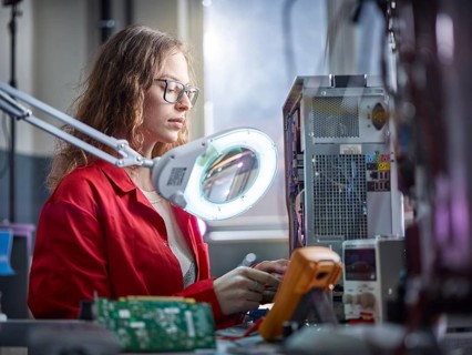 Technician measures with a measuring device in an electronics laboratory