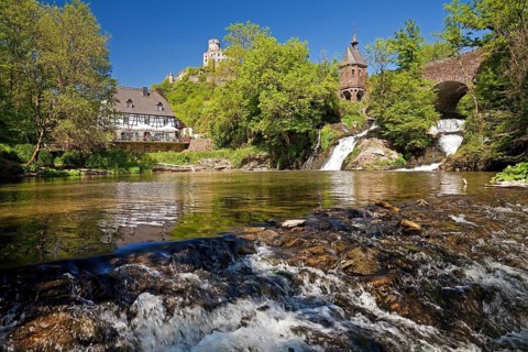 Pyrmonter mill at the waterfall of Elzbach with the castle Pyrmont in the back