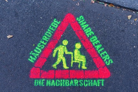 Warning sign against thieves and drugs sprayed with phosphorus paint on street asphalt