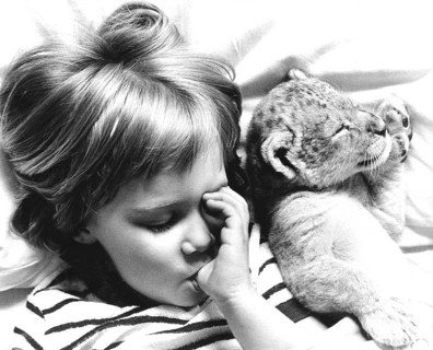 Girl and baby lion sleeping