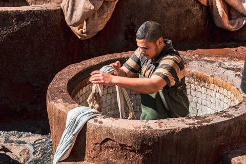 Worker dyeing leather
