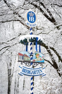 Beer garden sign in front of snow-covered trees