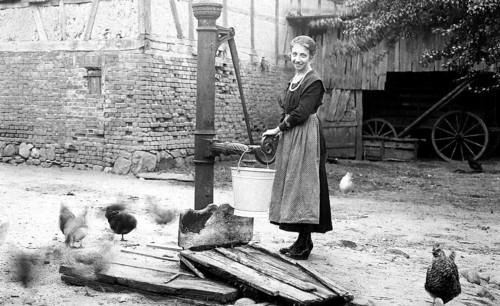 Farmer's wife gets water from a water pump