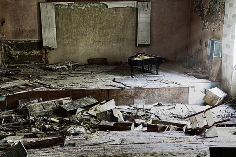 Stage with concert grand piano in destroyed building