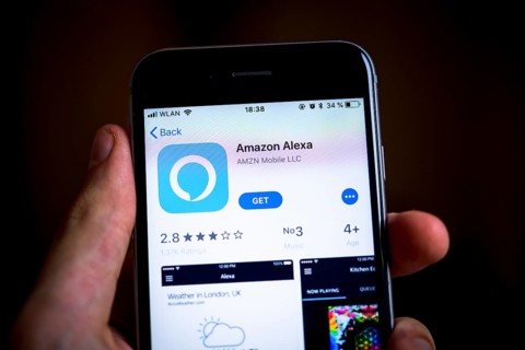 Hand holding iPhone with Amazon Alexa App in the Apple App Store