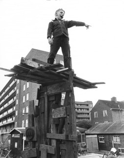 Boy on climbing object made of wood