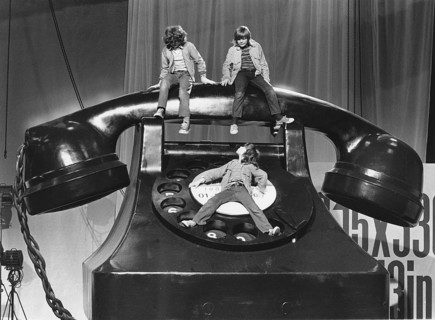 Three children on a large telephone