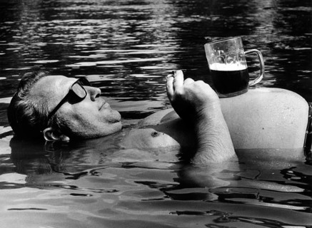 Man drinks beer in the water ca. 1970s