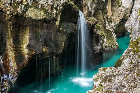 Emerald green wild river Soca flows through rocky gorge