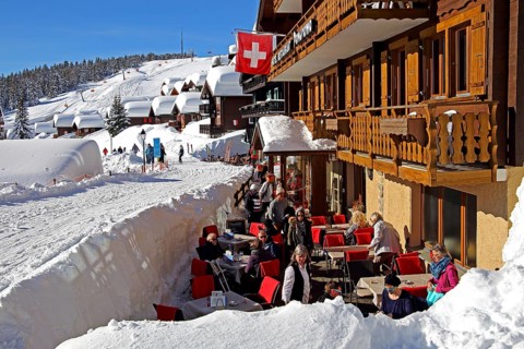 Restaurant terrace on the Dorfstrasse with snow-covered houses