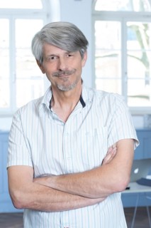 Man standing in his office with his arms crossed