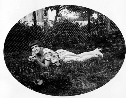 Young woman lying in the grass smoking