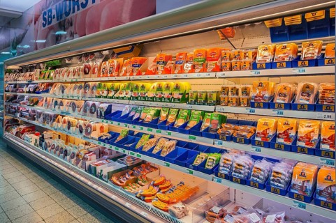 Shelf with packed sausages in supermarket