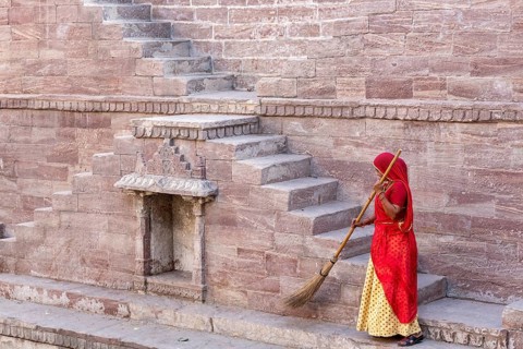 Woman in Sari cleaning the steps at Toorji Ka Jhalara