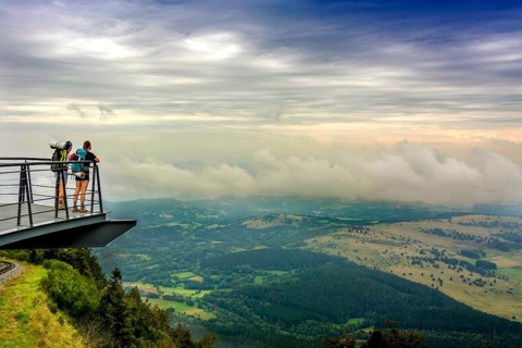 Walkers on a viewing platform facing the Limagne plain Regional Nature Park of the Volcanoes of Auvergne