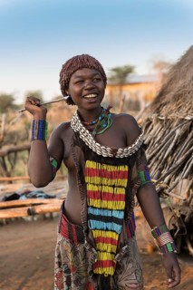 Young girl in traditional dress with necklace and spear